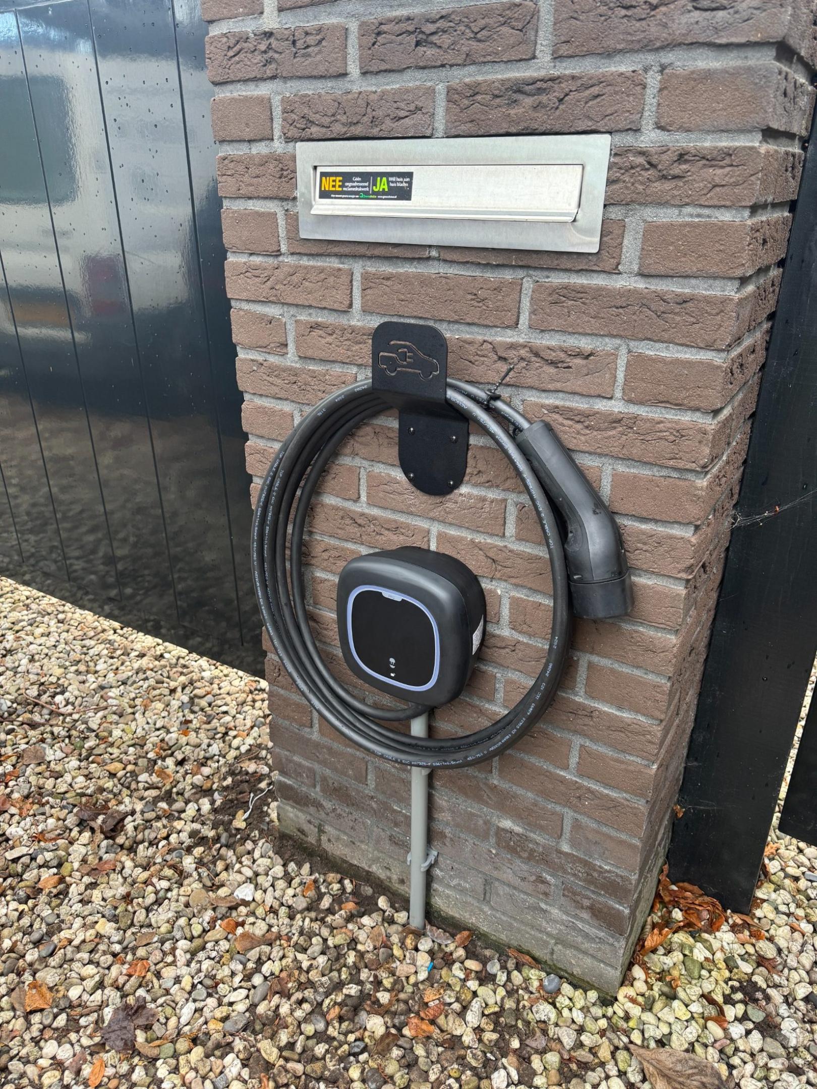 Wallbox Pulsar Pro laadpaal gemonteerd op gemetselde pilaar met opgerolde vaste laadkabel